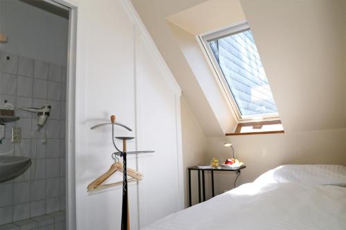 a bedroom with a bed and a bathroom with a window at Hotel Altstadt-Passage in Wittingen
