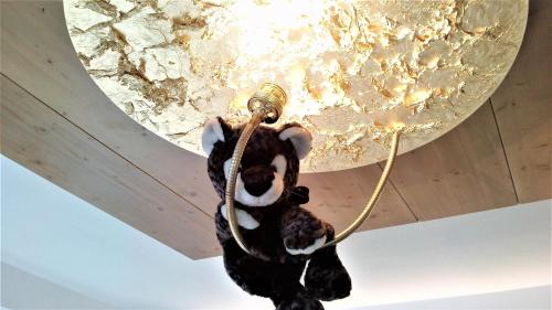 un osito de peluche colgado de una luz del techo en Hotel Vergeiner, en Seefeld in Tirol