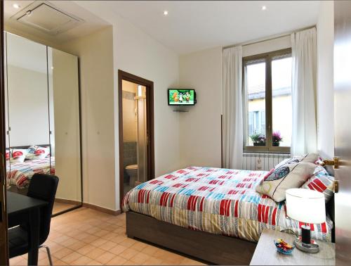 una camera da letto con un letto, una scrivania e una televisione di San Pietro's Home a Roma