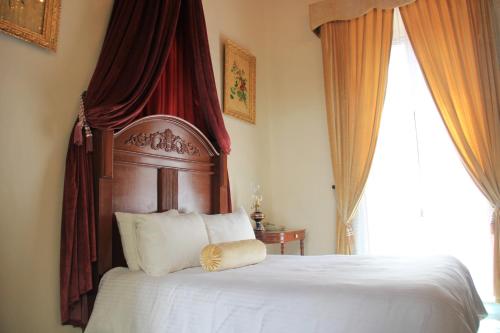 a bedroom with a bed with a canopy and a window at La Casa del Marqués in Comitán de Domínguez
