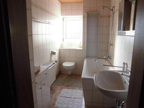 a bathroom with a tub and a sink and a toilet at Ferien-bei-Seifert in Dresden