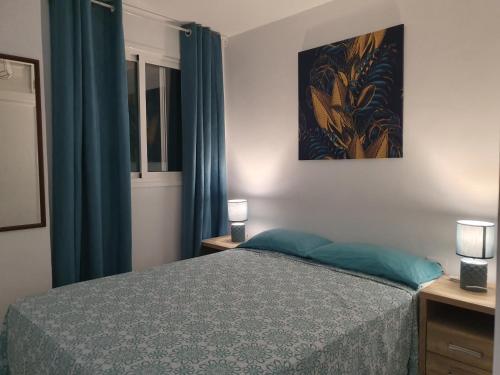 ロス・クリスティアーノスにあるLas Vistasのベッドルーム(ベッド1台、青いカーテン付)
