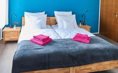 a large bed with two pink pillows on it at SCHLAFGUT! HOTEL-WILL.ICH Garni in Willich