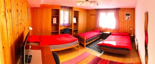 ヴェルビエにあるMAP Verbier-Villageのベッド2台とソファが備わる小さな客室です。