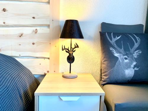 a lamp on a night stand next to a bed at Holiday apartment Bolgen - close to everything! Bolgen, Jakobshorn, bus stop, train station, supermarket, ski school, ski rentals, restaurants and more! in Davos