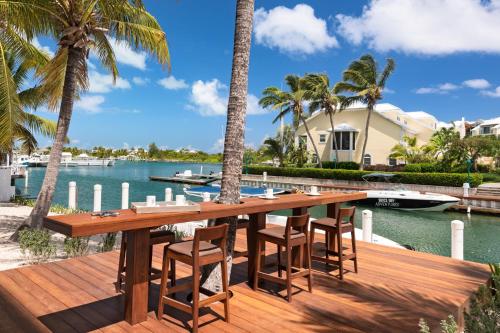 a wooden deck with a table and chairs next to the water at Zenza Boutique Hotel in Providenciales