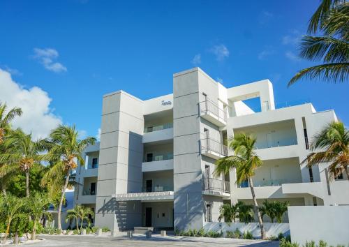 a white building with palm trees in front of it at Zenza Boutique Hotel in Providenciales