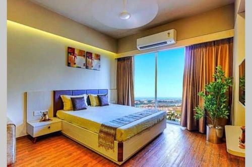 a bedroom with a large bed and a large window at Studio Stays in Surat
