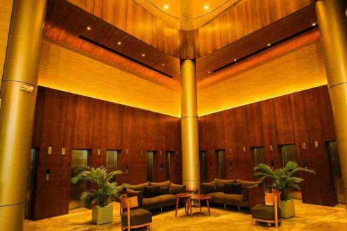 a lobby with couches and tables in a building at Weekend Stays in Surat