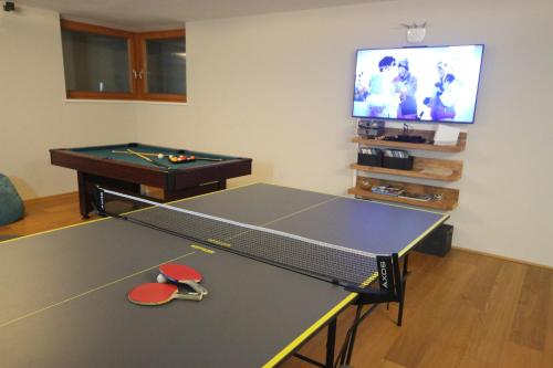 a room with a ping pong table and a tv at Appartements Julia in Zell am See