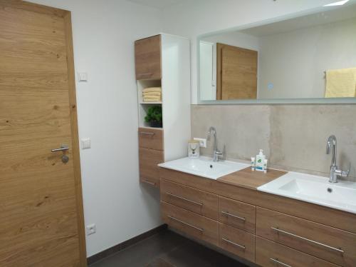 a bathroom with two sinks and a mirror at M4 Appartements in Wagrain