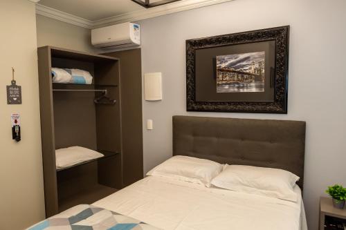 Кровать или кровати в номере Nilmare Apartamentos e Suites para suas Férias