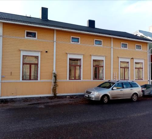 un edificio con dos coches estacionados frente a él en Foggy Island B&B, en Kaskö