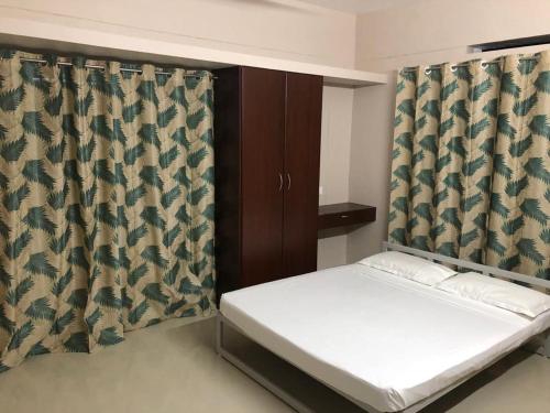 a bedroom with a bed and a curtain at Nachiyar Suites in Trivandrum