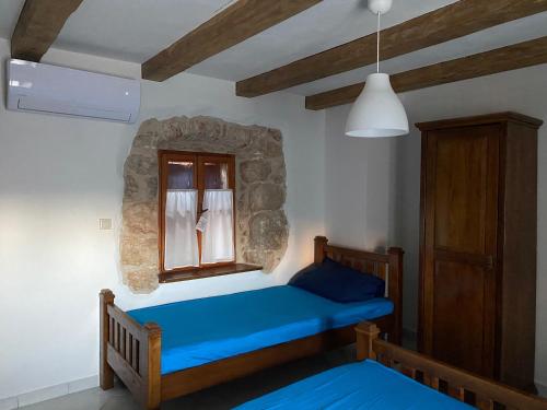 a bedroom with a blue bed and a window at Holiday Home Hauser in Vrbanj