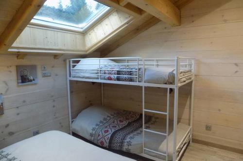 a room with two bunk beds in a cabin at CHALET DES CHARBONNIERS AVEC ETANG in Saint-Maurice-sur-Moselle