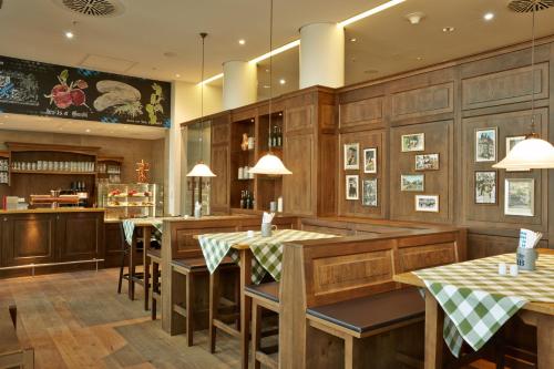 a restaurant with wooden walls and tables and chairs at H4 Hotel München Messe in Munich