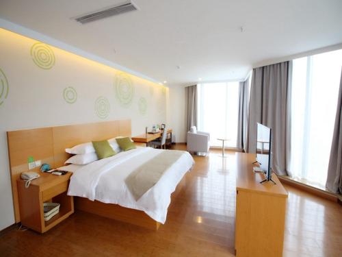 una camera da letto con un letto grande e una televisione di GreenTree Inn Suzhou South zhongshan Road Shangyi Bus Station Express Hotel a Suzhou
