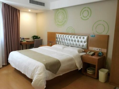 GreenTree Inn Anhui Fuyang Yingzhou district Positive base capital Business Hotel tesisinde bir odada yatak veya yataklar
