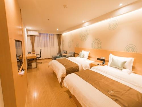 a hotel room with two beds and a desk at GreenTree InnZhangjiakou High-speed Railway Station Business Hotel in Zhangjiakou