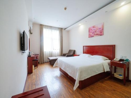 a hotel room with a bed and a couch at GreenTree Inn Henan Zhengzhou Chengnan Road Bojue Business Hotel in Zhengzhou