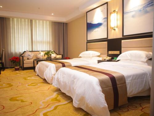 um quarto de hotel com três camas num quarto em GreenTree Alliance Texas Ningjin County Zhengyang Road Debai Plaza Hotel em Dezhou