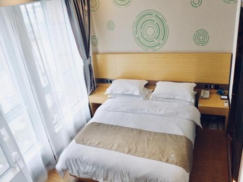 a bedroom with two beds and a large window at GreenTree Inn HuaiAn Area for development Shenzhen East Road Express Hotel in Huai'an