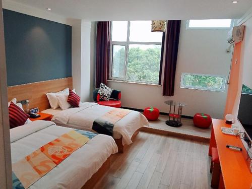 una camera d'albergo con due letti e una finestra di Shell Tai'an Taishan District Xinhuacheng International Plaza Hotel a Tai'an
