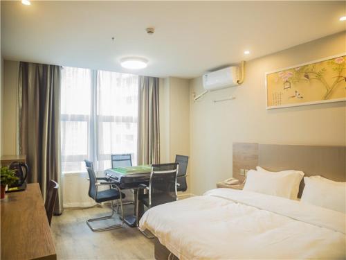 a hotel room with a bed and a table with chairs at Shell Wuhu City Jinghu District Rehabilitation Road Hotel in Wuhu