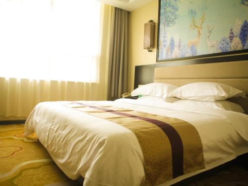 a large bed in a hotel room with a window at GreenTree Alliance Texas Ningjin County Zhengyang Road Debai Plaza Hotel in Dezhou