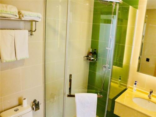 a bathroom with a glass shower and a sink at GreenTree Inn HuaiAn Area for development Shenzhen East Road Express Hotel in Huai'an