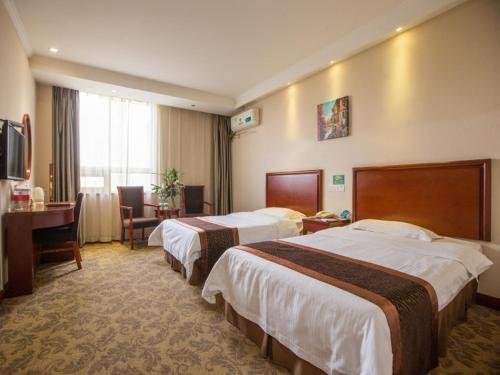 a hotel room with two beds and a desk at Greentree Inn Anhui Hefei South High-speed Rail Station Fanhua Avenue Haiheng Express Hotel in Hefei