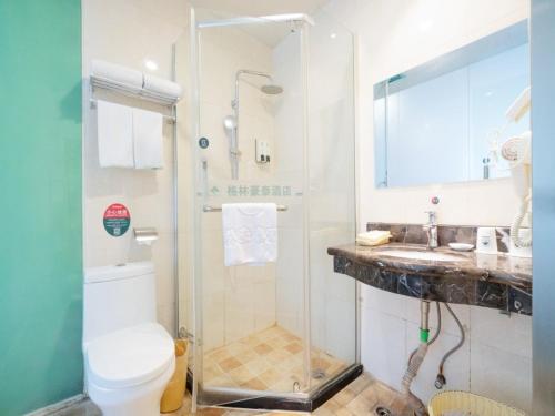 a bathroom with a shower and a toilet and a sink at GreenTree Inn Henan Zhengzhou Chengnan Road Bojue Business Hotel in Zhengzhou
