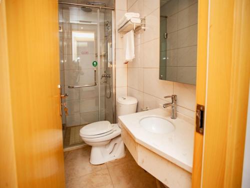 a bathroom with a toilet and a shower and a sink at Shell Huai'an Fishing Hook Town Hotel in Huai'an