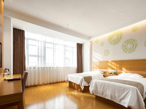 Habitación de hotel con 2 camas y escritorio en GreenTree Inn Changzhou Xixiasu Town Express Hotel en Luoxi