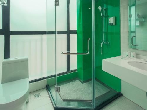 een badkamer met een glazen douche en een wastafel bij GreenTree Inn Guangxi Zhuang Autonomous Region Guilin Lingui District Luhu International Express Hotel in Guilin