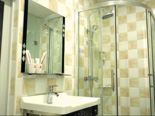 a bathroom with a sink and a shower at Shell Haikou Xiuying District Hainan University Hotel in Haikou