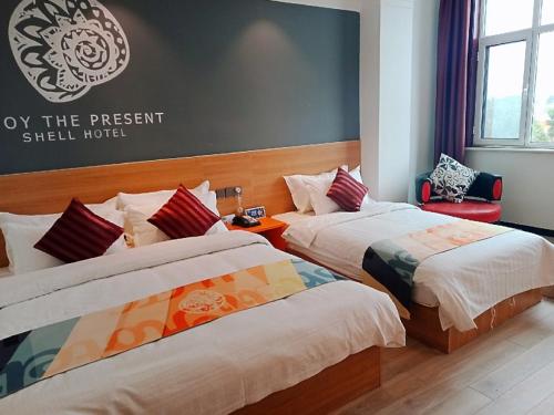 a hotel room with two beds and a sign on the wall at Shell Tai'an Taishan District Xinhuacheng International Plaza Hotel in Tai'an
