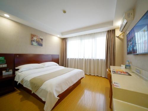 a hotel room with a large bed and a window at GreenTree Inn Shanghai Baoshan Yanghang Shuichan Road Hotel in Baoshan