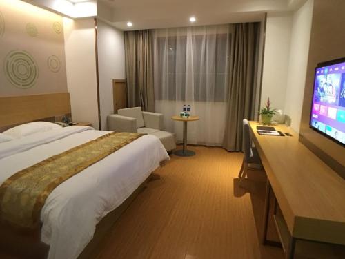 a hotel room with a bed and a flat screen tv at GreenTree Inn Shaoxing Binhai New City Dongsen Commercial Square Hotel in Shaoxing