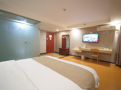 a hotel room with a large bed and a television at GreenTree Inn Shanghai Baoshan Yanghang Shuichan Road Hotel in Baoshan