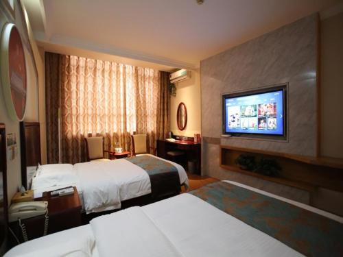 a hotel room with two beds and a flat screen tv at GreenTree Inn JiangSu WuXi YangJian XiHu Road Express Hotel in Wuxi