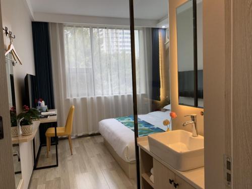 a bathroom with a bed and a sink and a mirror at Shell Xi'an Yanta District Jixiang Village Subway Entrance Hotel in Xi'an