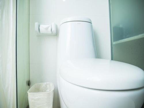 a bathroom with a white toilet and a shower at GreenTree Inn Jinhua Railway Station Express Hotel in Jinhua