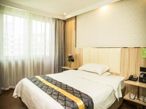 a hotel room with a bed and a window at GreenTree Inn Jinhua Railway Station Express Hotel in Jinhua