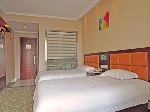 a hotel room with two beds and a window at GreenTree Inn Anhui Hefei Tianehu Wanda Square Express Hotel in Hefei