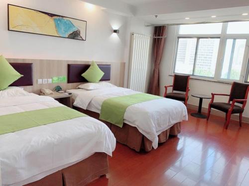 a hotel room with two beds and a table and chairs at GreenTree Inn ShanDong Jinan Railway Station Provincial Hospital Jinger Road Express Hotel in Jinan