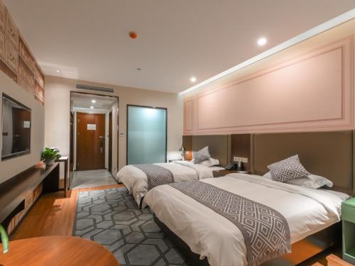 um quarto de hotel com duas camas e uma televisão em GME Hefei Fuyang North Road Beicheng Hotel em Hefei