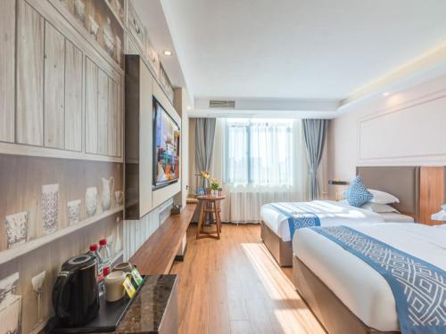 a large hotel room with two beds and a table at Gme Fuyang Guangming South Road Hotel in Fuyang