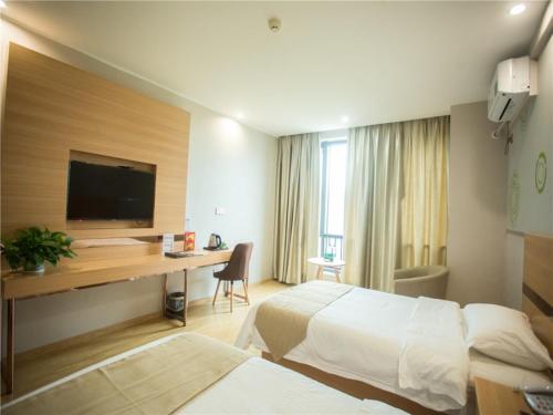 a hotel room with two beds and a desk at GreenTree Inn Zhoushan Baiquan Colorful Plaza Express Hotel in Zhoushan